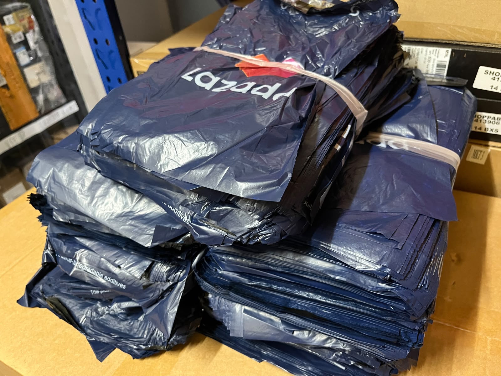 Stack of lazada pouches on a cardboard surface with boxes in the background